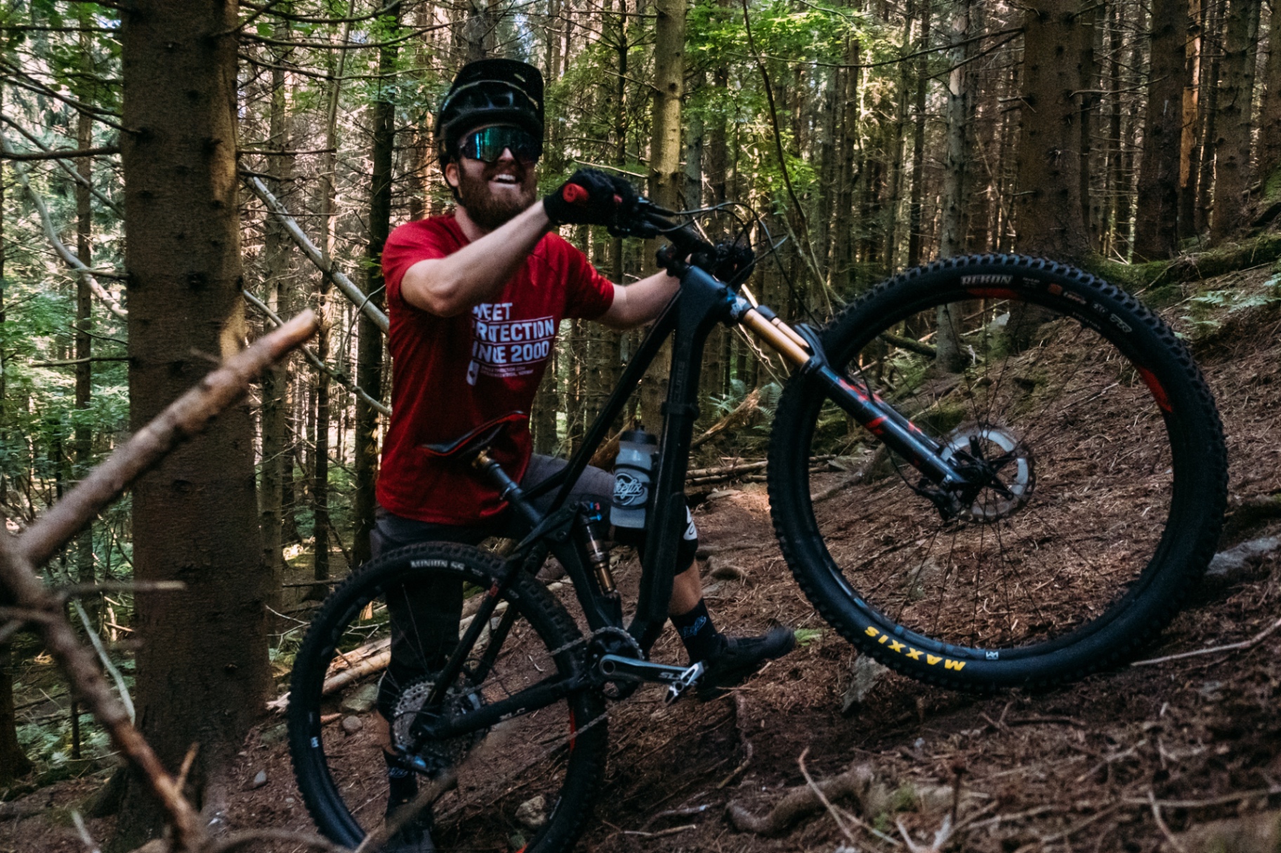 Glad cyklist med MTB i skogen