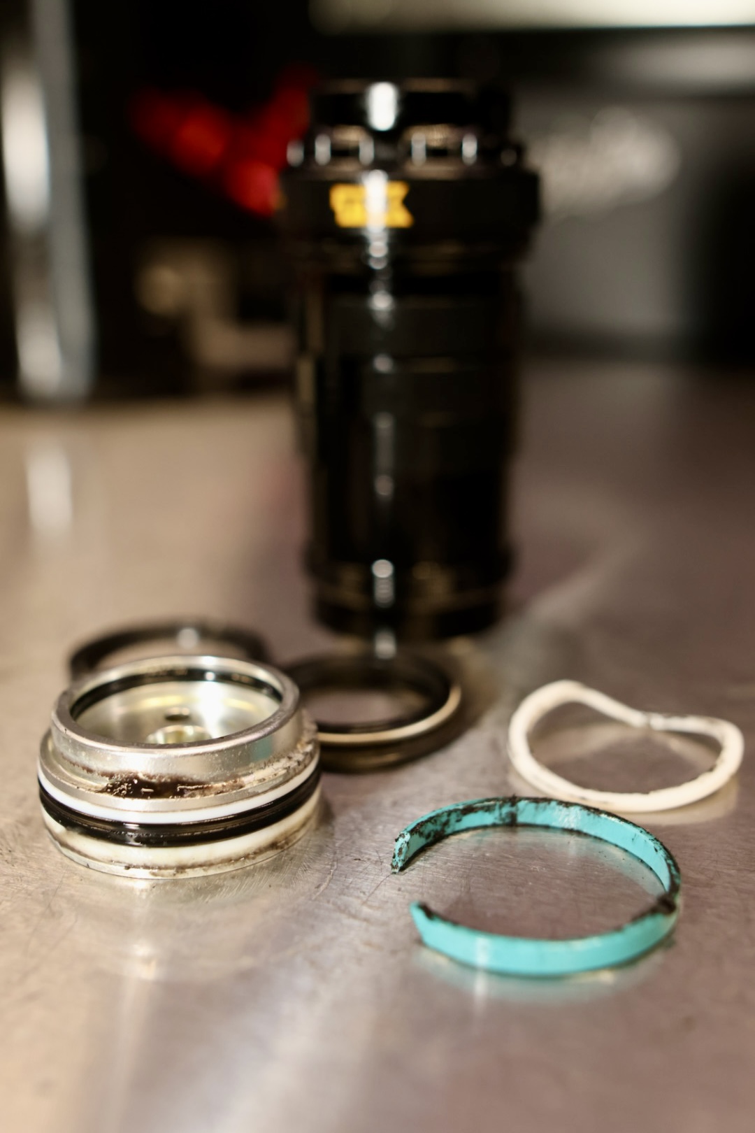 Öhlins TTX Air isärplockad med slitna tätningar, glidlager och back-up-ringar på Bikefix verkstadsbänk