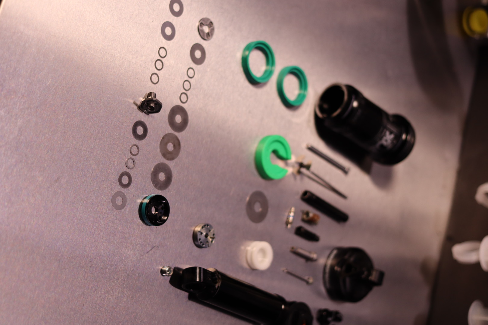 RockShox MTB-bakdämpare teardown med gröna SKF-tätningar, IFP-piston och shim-stack på Bikefix verkstadsbänk